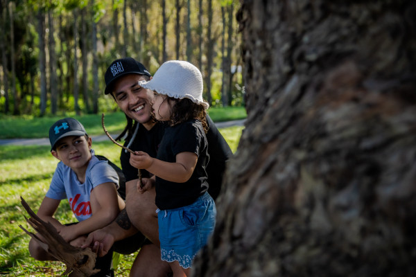 Dad playing with his kids outside. 