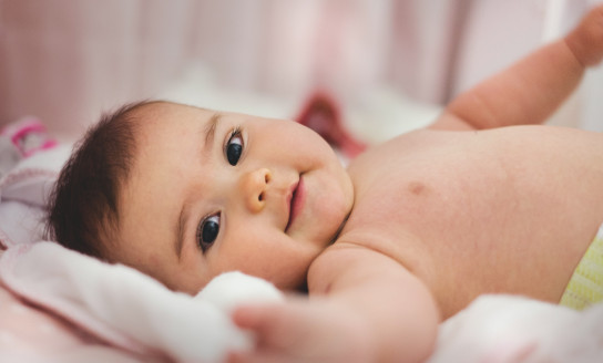 baby lying on pink bed 1556706 v2