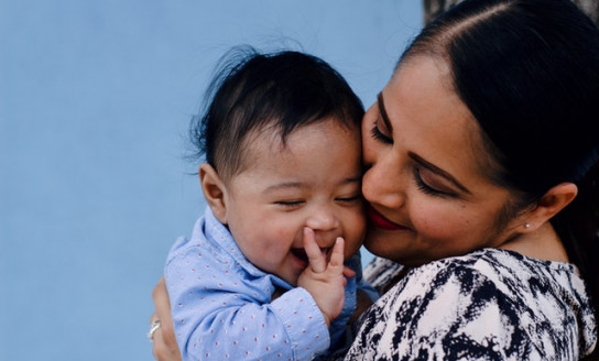 close up photo of smiling woman carrying her smiling baby 3766464