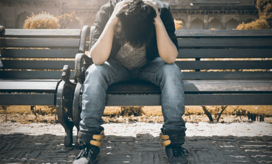 man in black shirt and gray denim pants sitting on gray 1134204