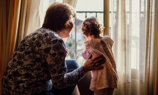 woman holding baby near window 1109238